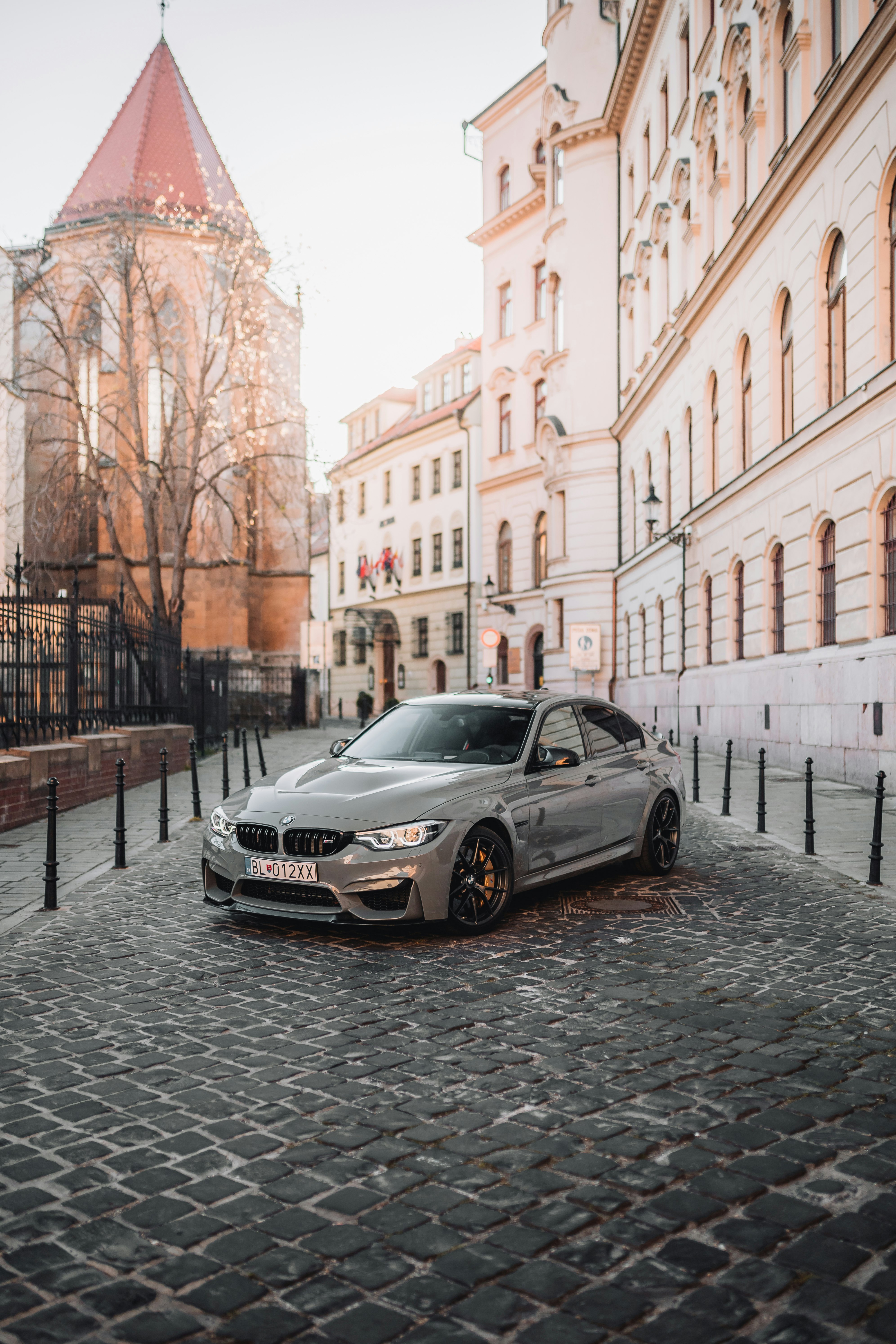 black mercedes benz coupe parked on sidewalk during daytime